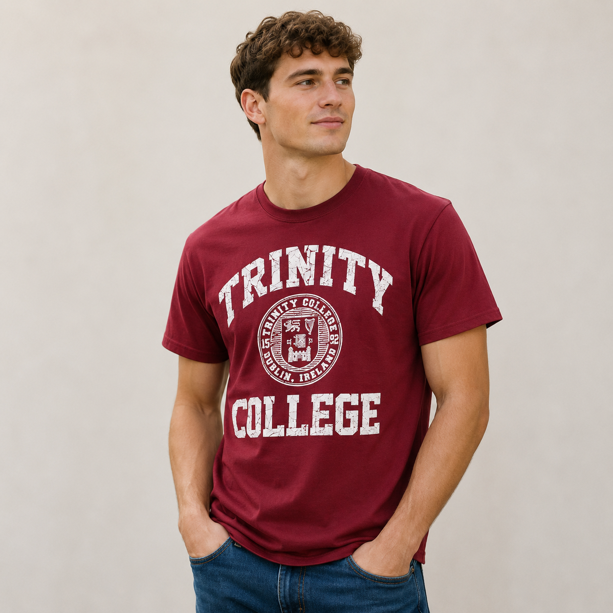 Man wearing a maroon 'Trinity College' t-shirt against a plain background